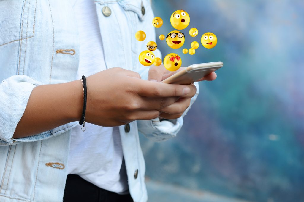 women-using-phone-expressing-herslef-with-emojis